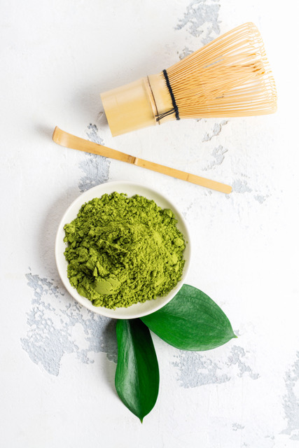 Green matcha tea powder and tea accessories on white background. Japanese tea ceremony concept. Copy space