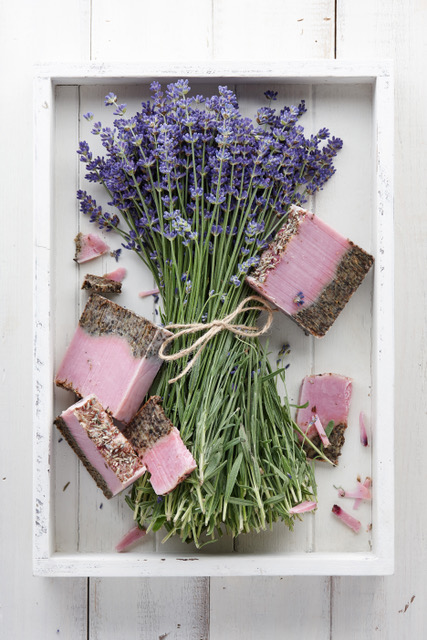 Lavender soap and beautiful lavender flowers in white box, top view